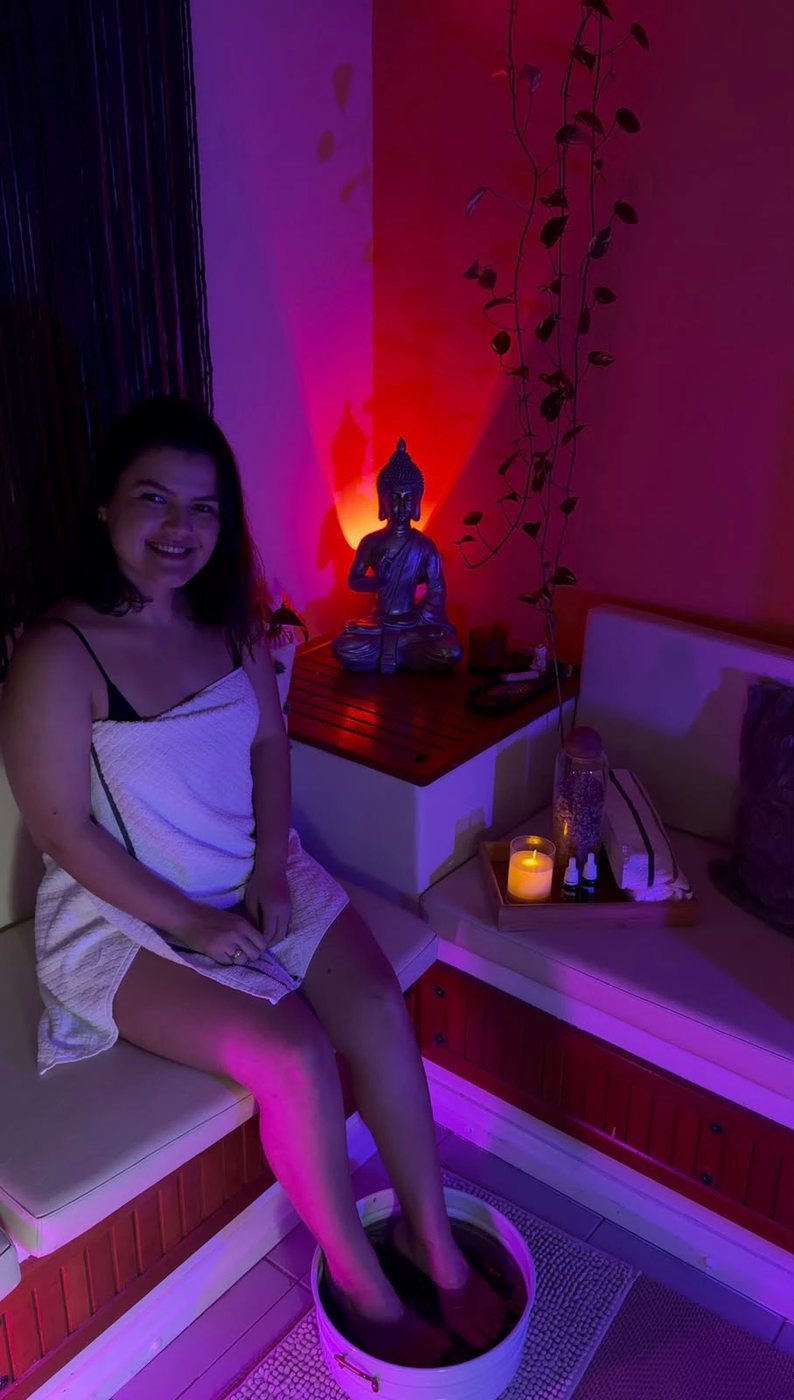 Sala de atendimento do Ramony Wellness Center com escalda-pés, vela, plantas e luz suave